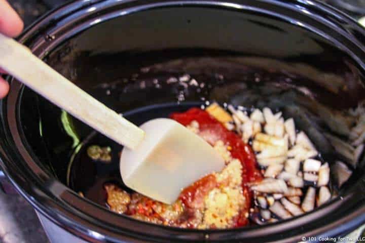 mixing spices and onion in crock pot