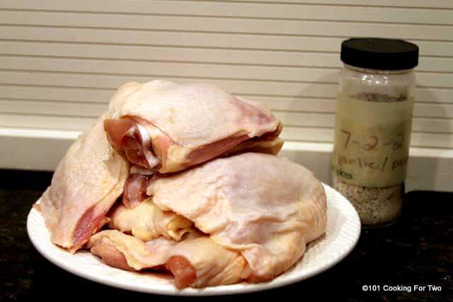 A pile of raw chicken and seasoning