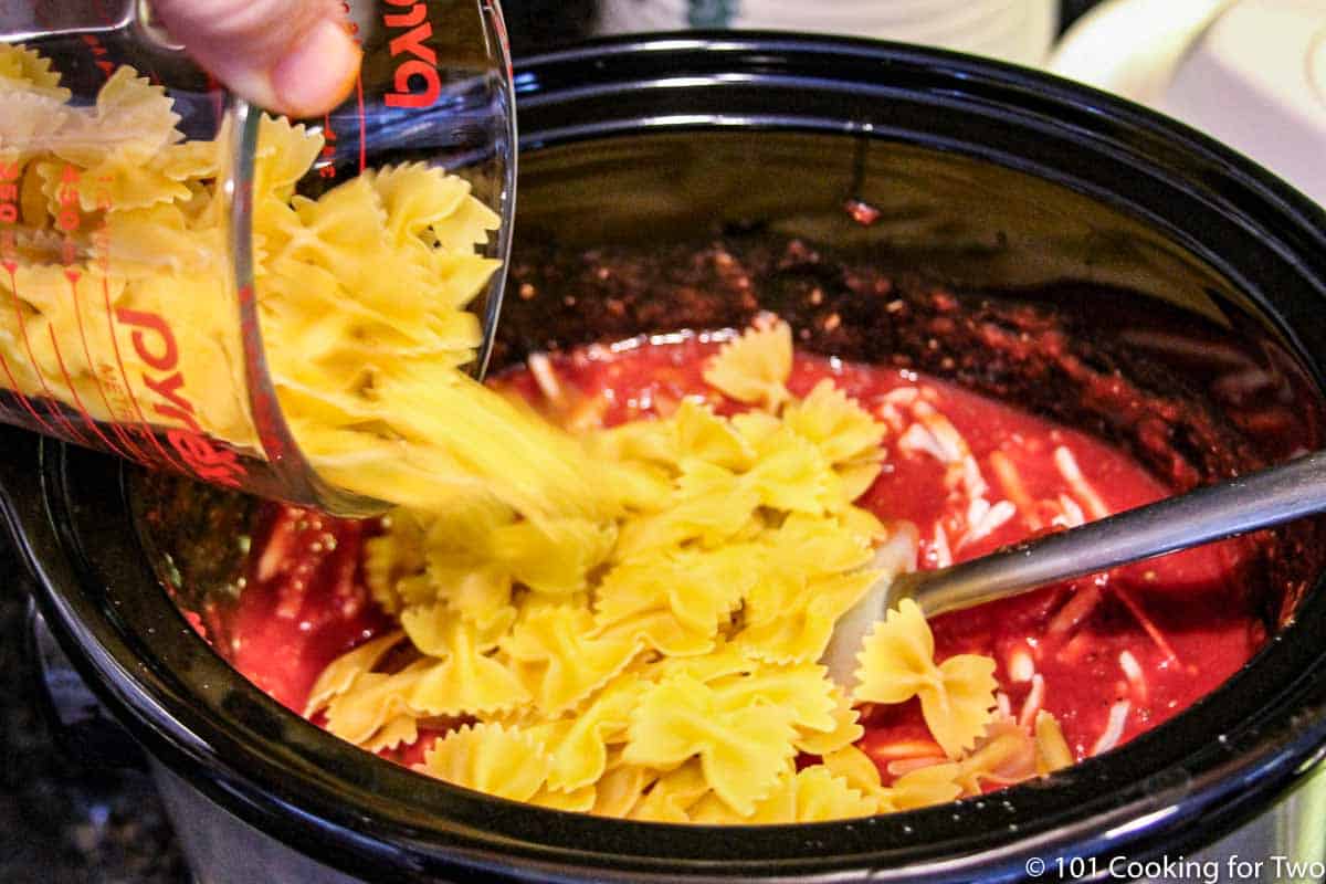 https://www.101cookingfortwo.com/wp-content/uploads/2021/09/adding-pasta-to-crock-pot-with-sauce.jpg