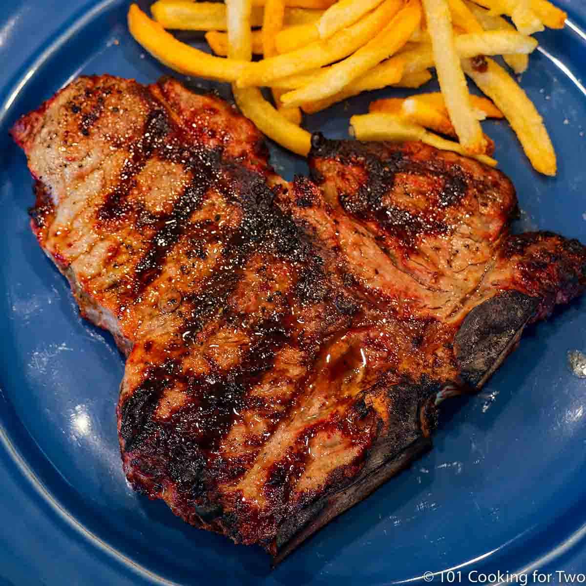 https://www.101cookingfortwo.com/wp-content/uploads/2023/01/perterhouse-steak-with-fries-on-blue-plate.jpg