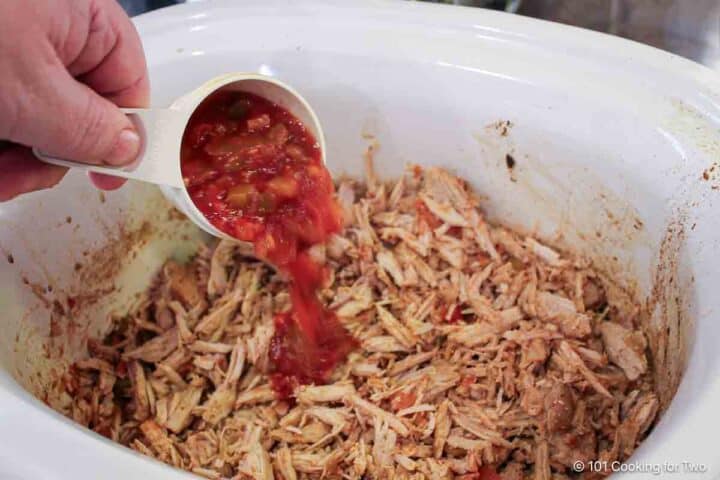 adding salsa to pulled pork.