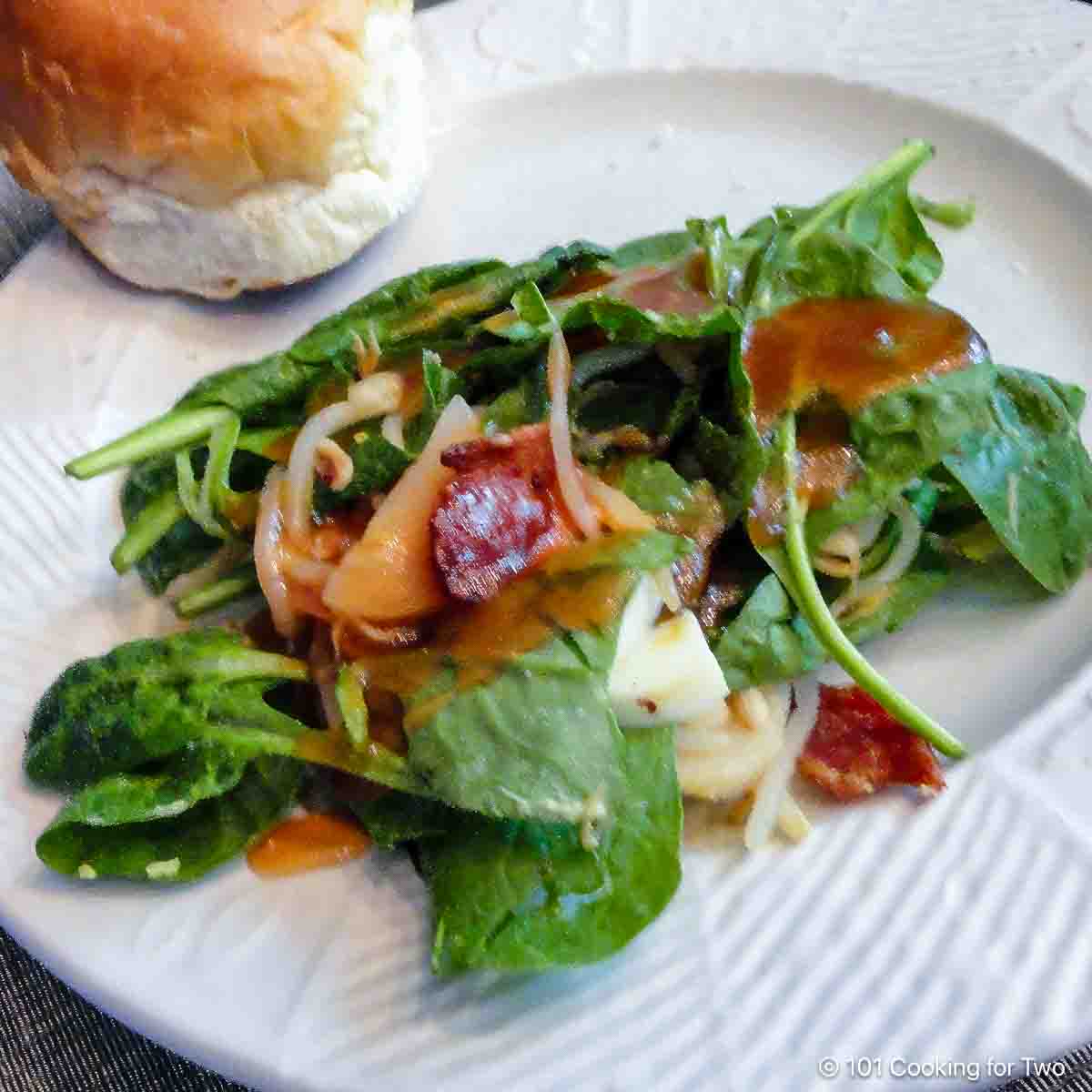 fresh spinach salad on white plate.