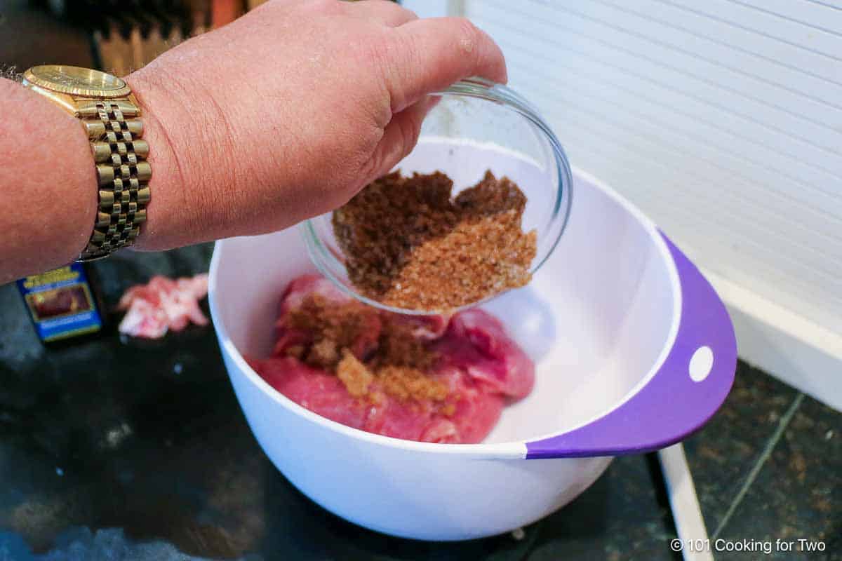 Coating tenderloin with spice rub.