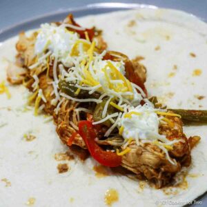 Chicken fajita with toppings on a gray plate.