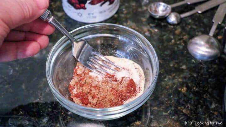 mixing spice rub in a small glass bowl.