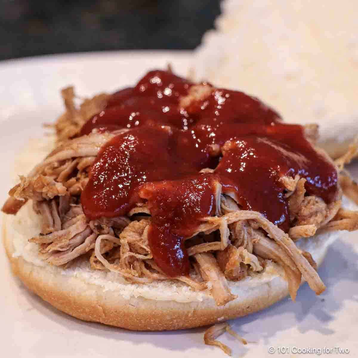 Shredded pork tenderloin with BBQ sauce on a bun.