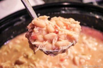 Ladle of chili over crock pot.