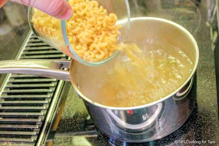 Pouring dry pasta into boiling water.