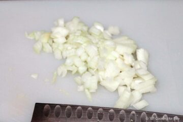 Chopped onions on a white board.