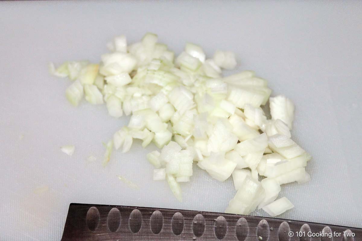 Chopped onions on a white board.