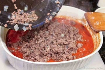 Mixing browned burger into the sauce.