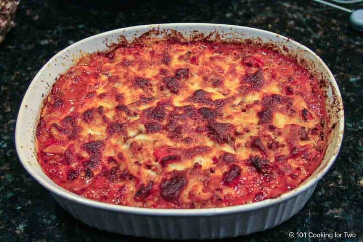 Topping goulash with cheese.