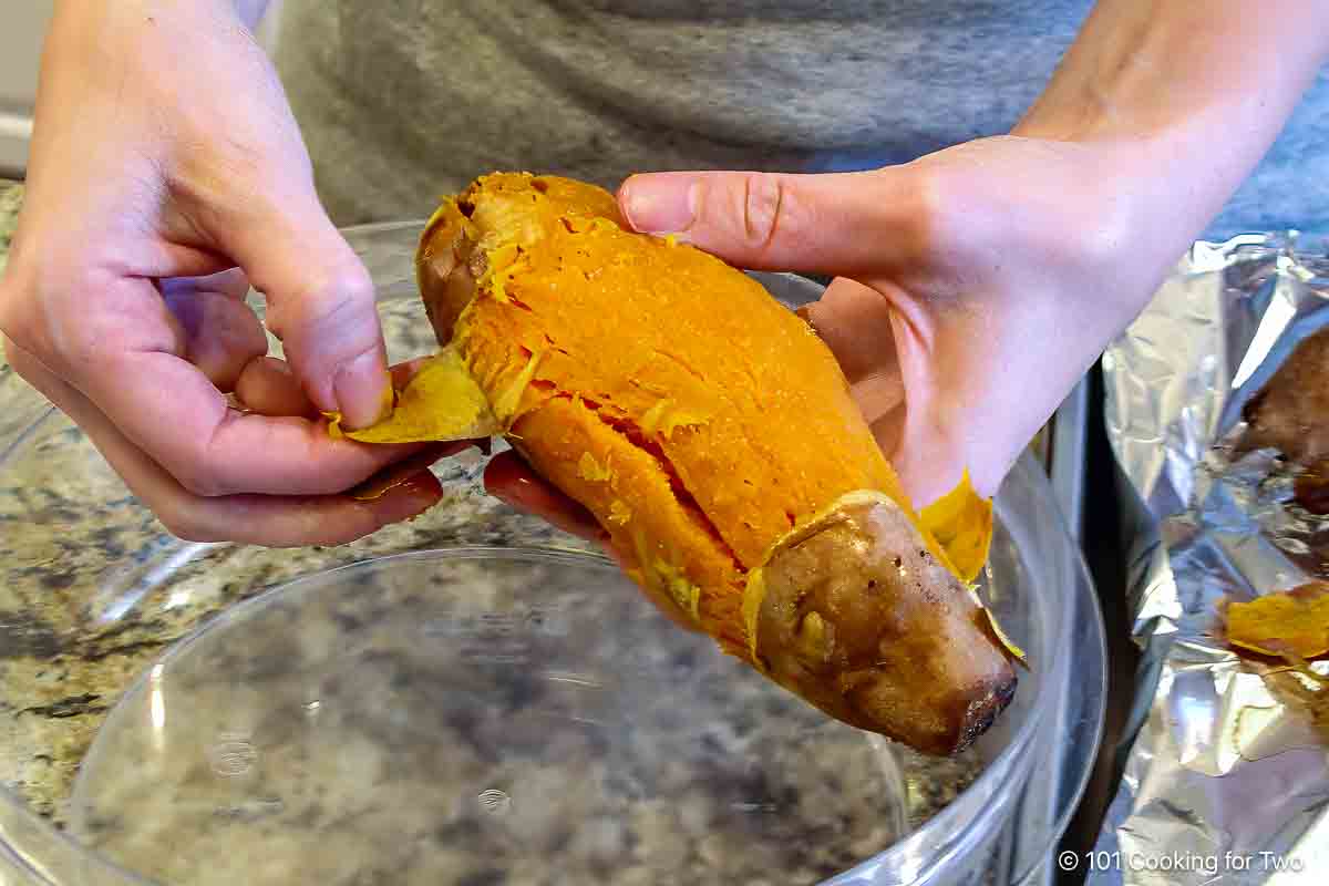 Peeling a cooked sweet potato by hand.