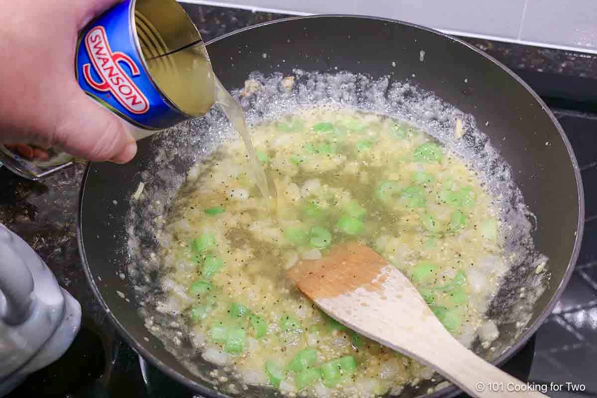 Adding broth to the sauce.