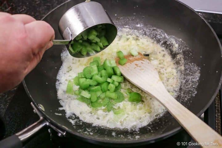 Adding chopped celery to the roux.