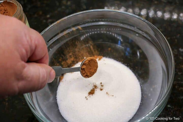 Adding cinnamon to sugar.