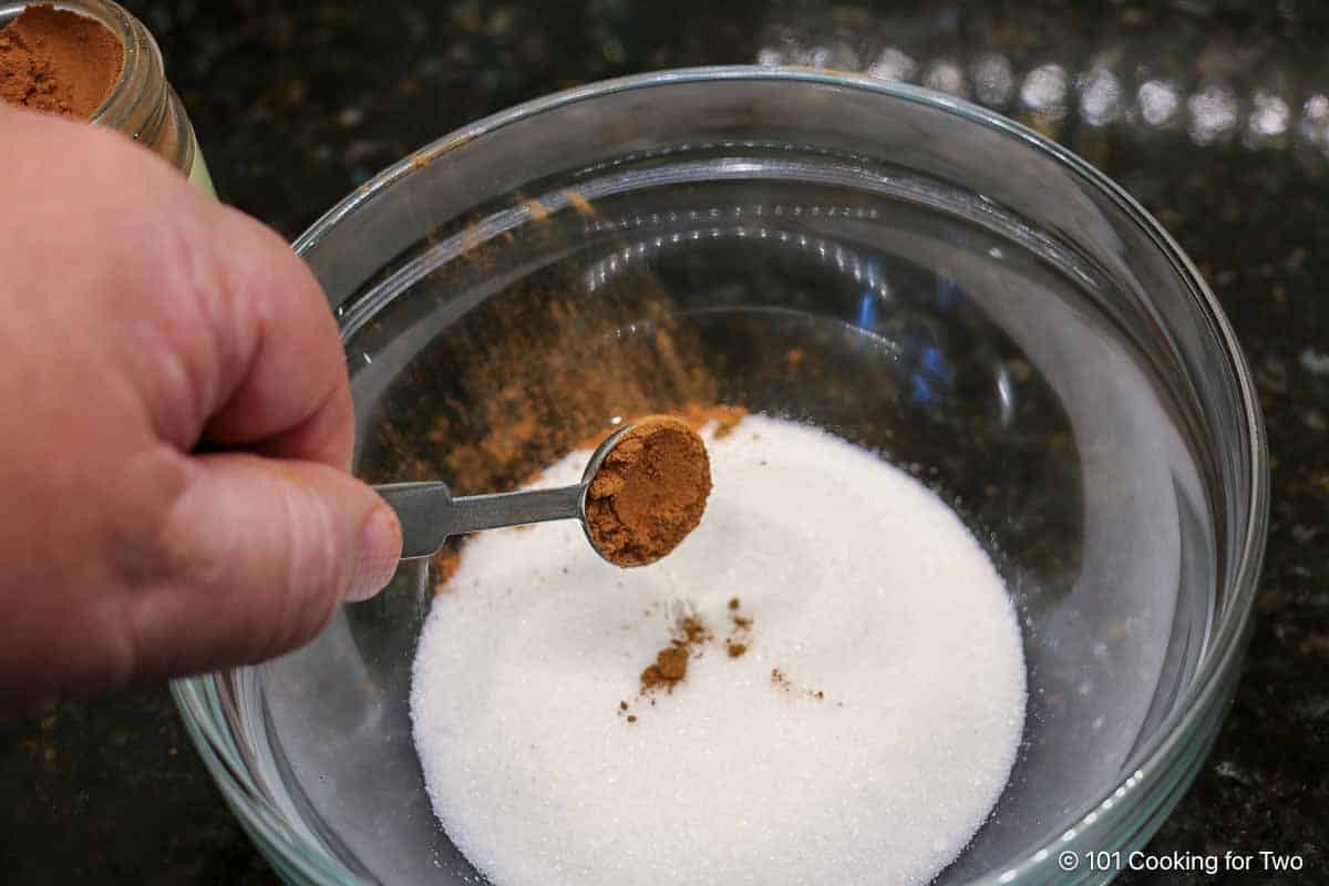 Adding cinnamon to sugar.