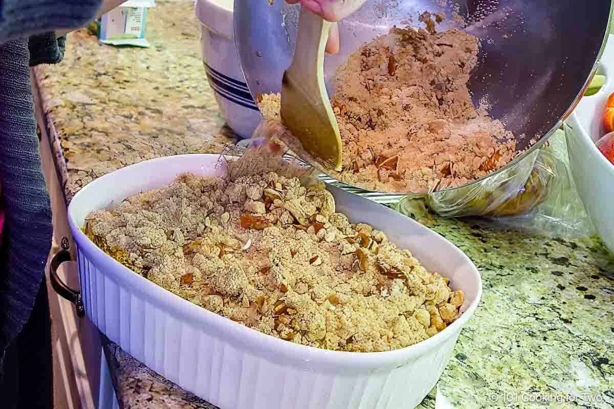 Adding topping to the casserole.