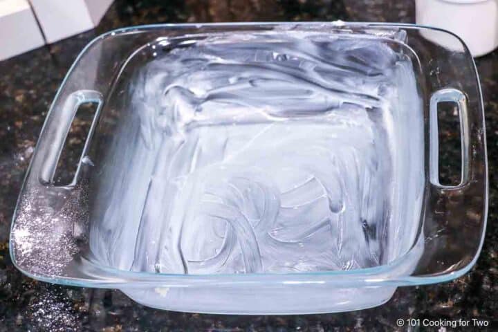 A baking dish prepared with butter.