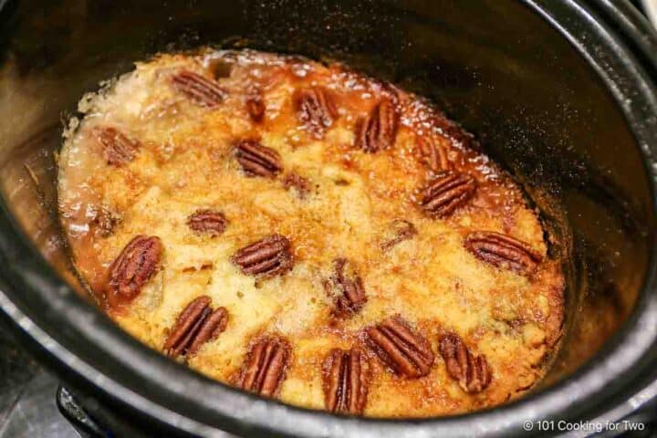 Cooked crock pot apple cobbler with brown top.