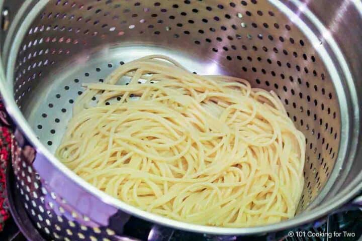 Draining cooked pasta.