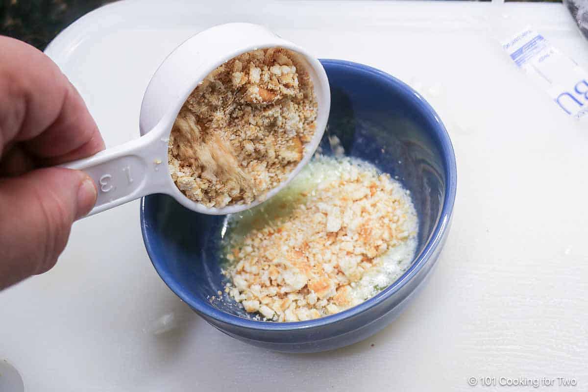 Mixing crushed Ritz crackers into butter.