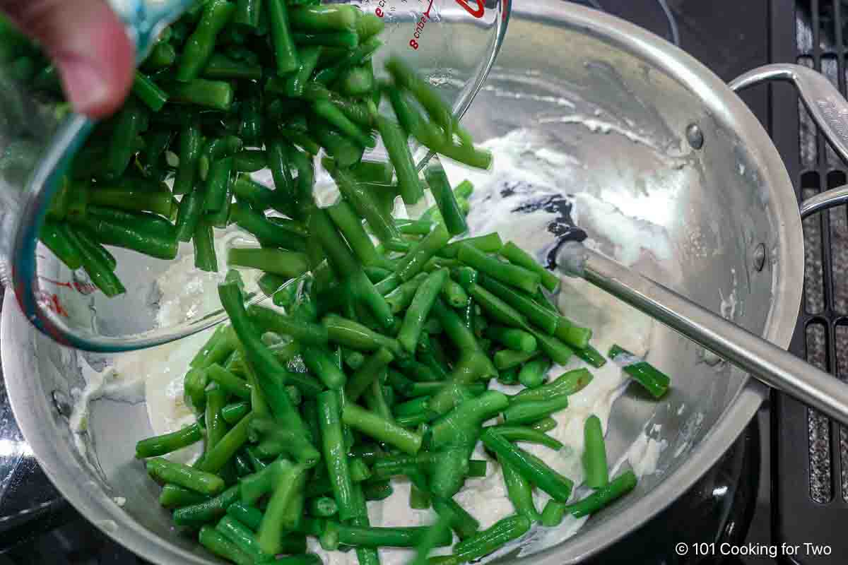 Mixing green beans and sour cream into the roux.