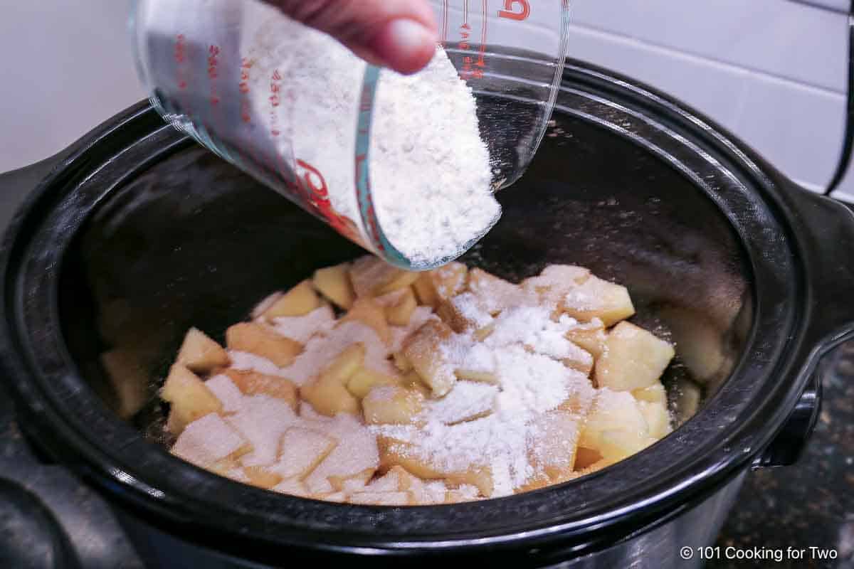 Pouring cake mix on the coated apples.