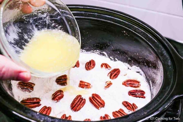 Pouring melted butter over the cobbler.