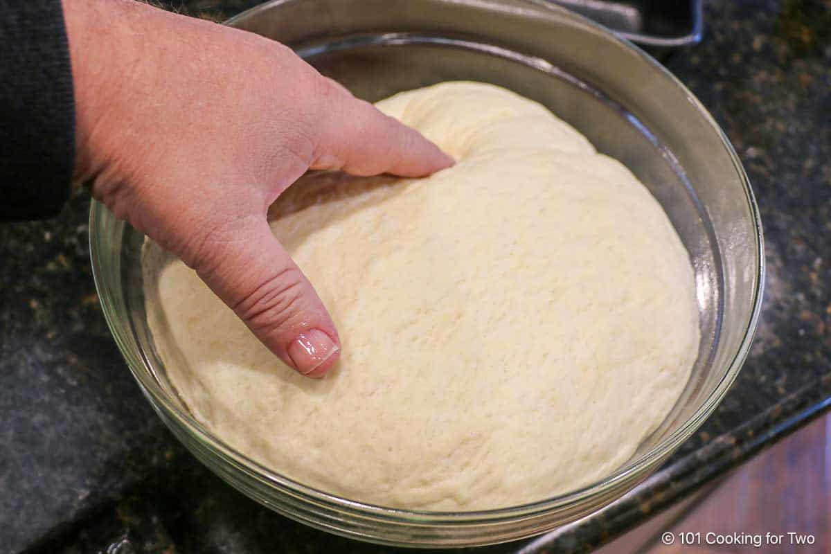 Punching down rising dough.