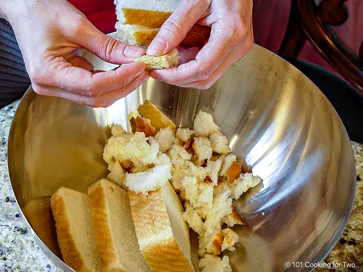 Ripping bread into small pieces.