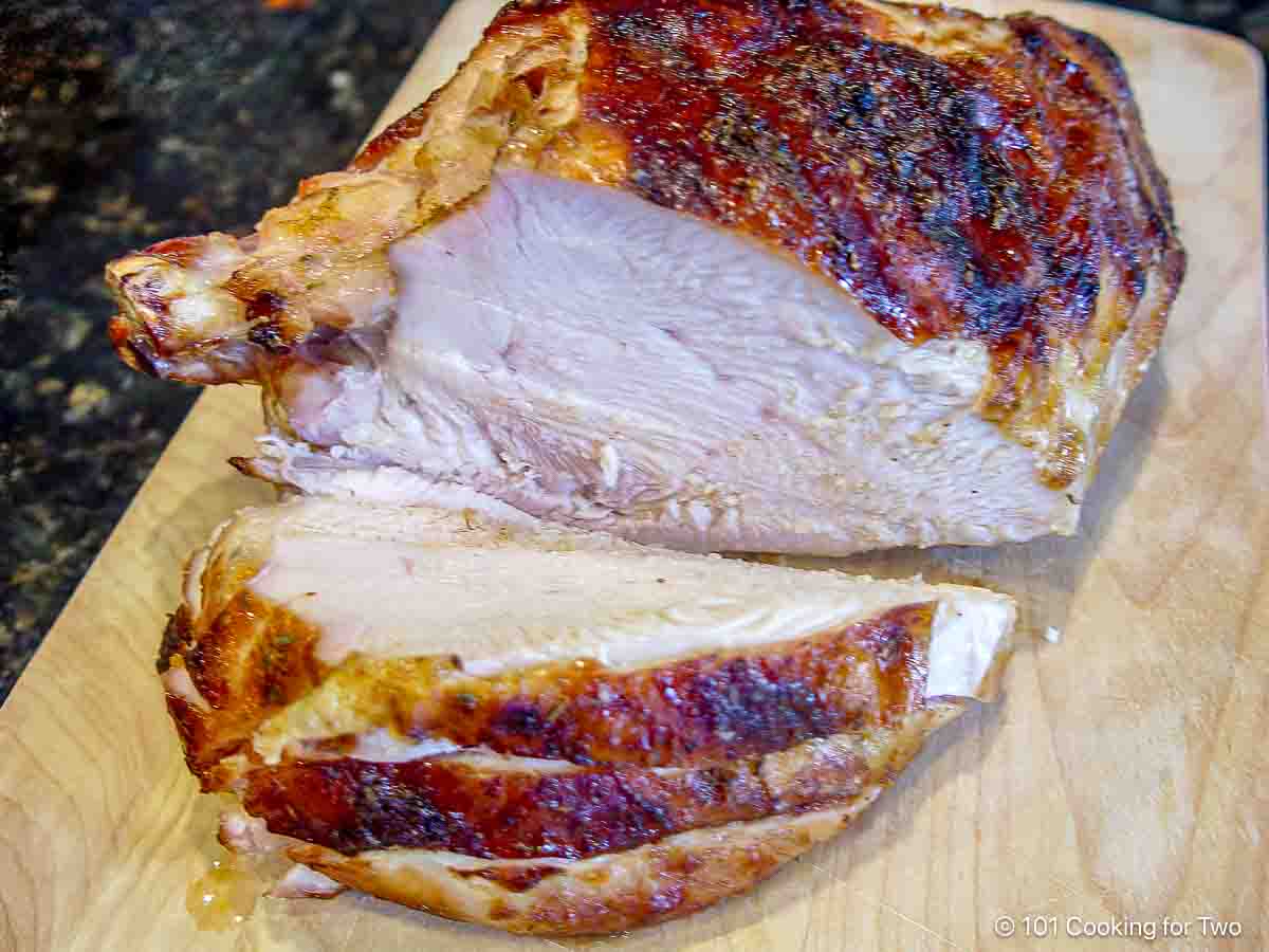 Slicing the grilled turkey on a board.