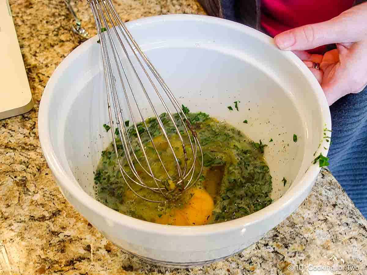 Whisking herbs with eggs.