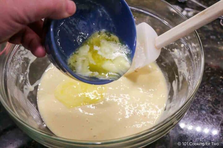 Adding melted butter to the batter.