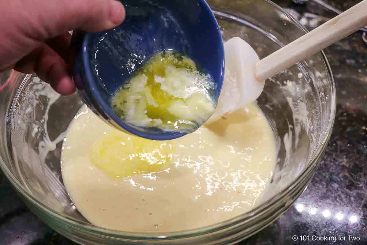 Adding melted butter to the batter.