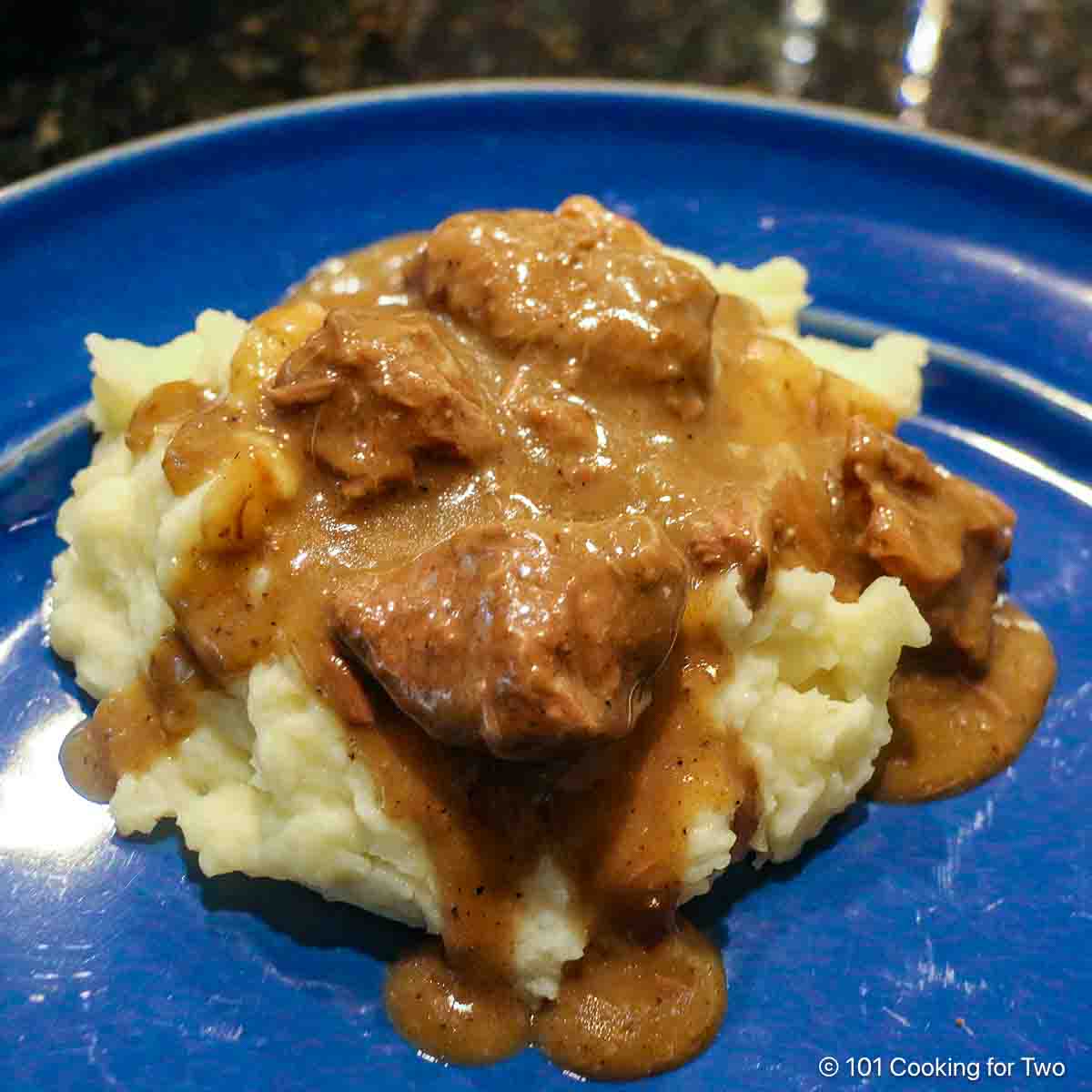 Beef tips with gravy on mashed potatoes.