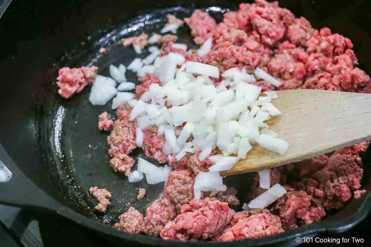 Browing burger with chopped onion.