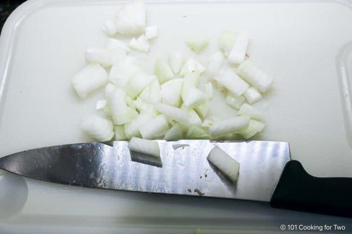 Chopping onion on a white board.