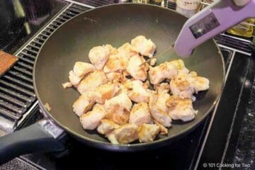 Cooking chunks of coated chicken in a pan.