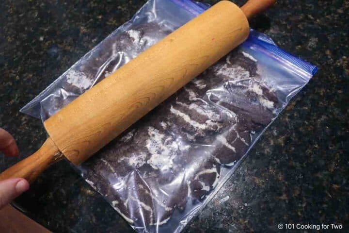 Crushing Oreo cookies in a plastic bag.