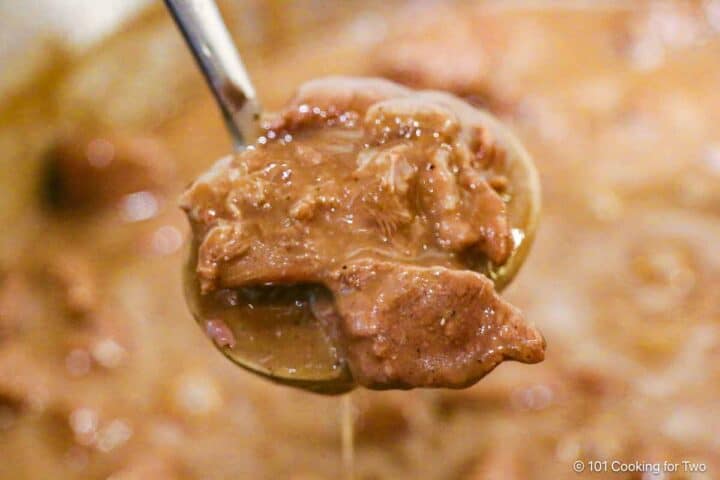 Ladle of beef and gravy.