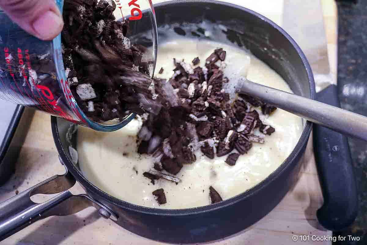 Mixing chopped Oreos into melted chocolate.