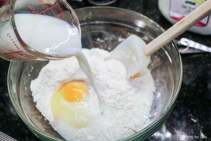 Mixing milk and egg into dry ingredients.