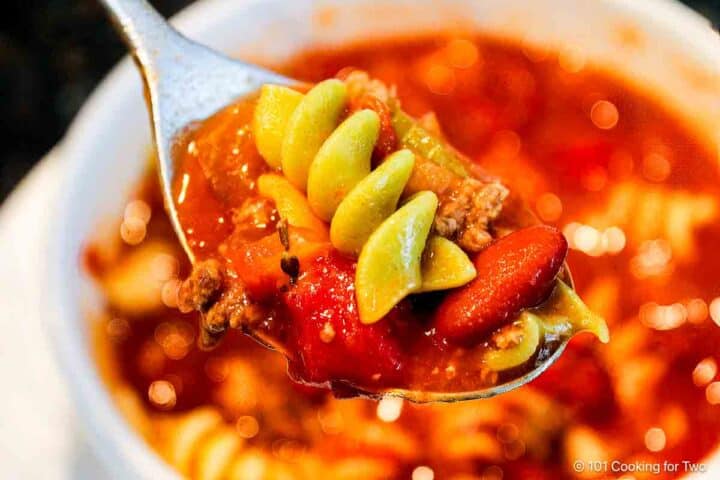 Pasta e Fagioli Soup on a spoon over the bowl.