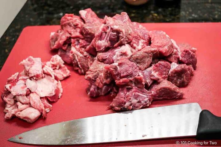 Trimming a chuck roast into cubes.