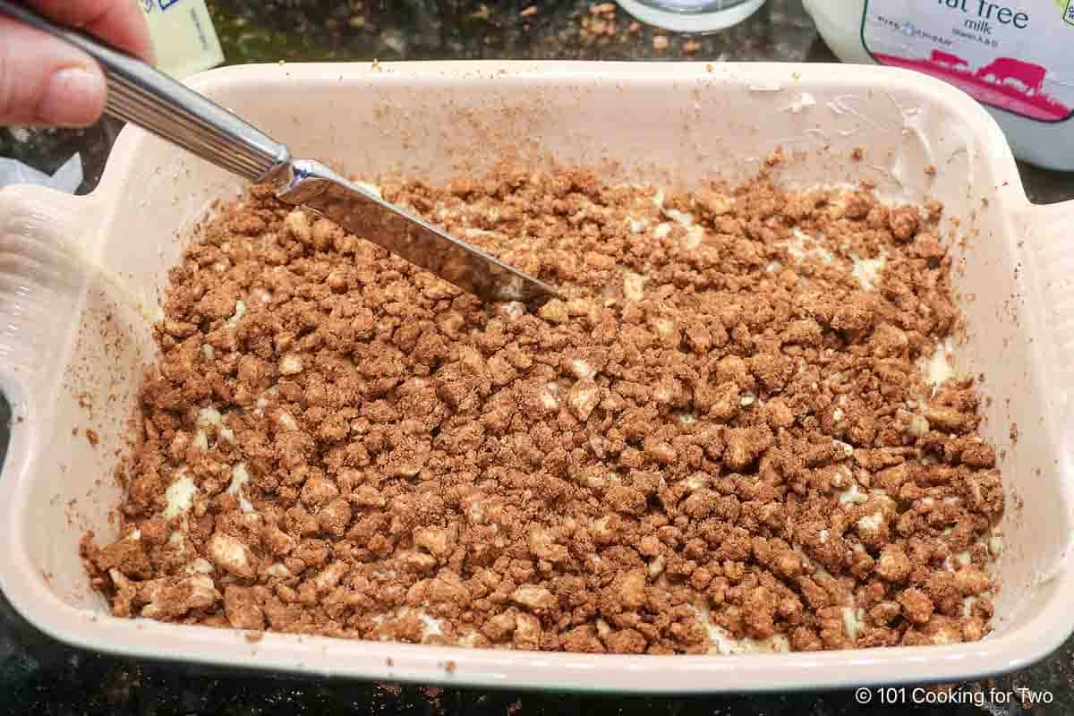 Using a knife to swirl topping into the batter.