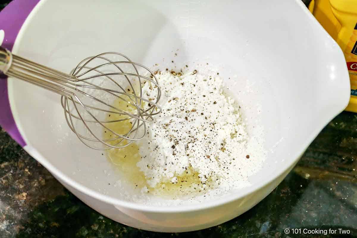 Whisking breading ingredients.