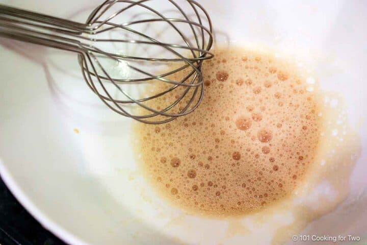 Whisking coating in a large bowl.