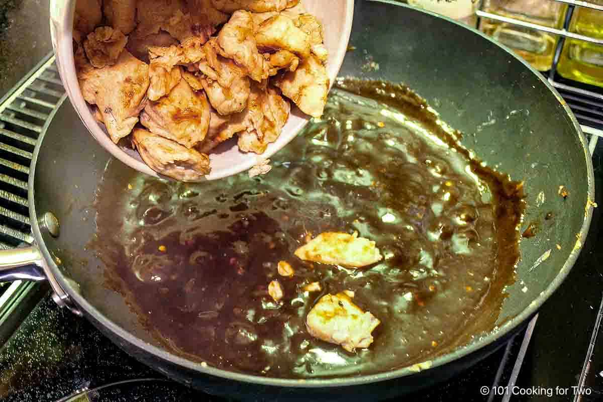 Adding cooked chicken into the sauce.