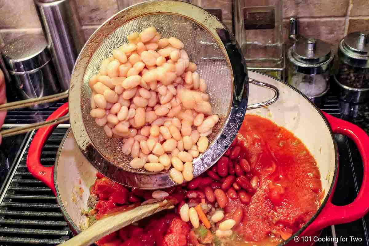 Adding rinsed beans to the soup.